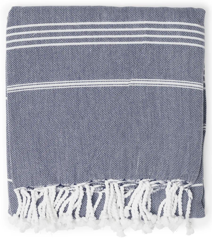 Tummansininen hamam-pyyhe, jossa on valkoiset raidat ja valkoiset hapsut reunassa.