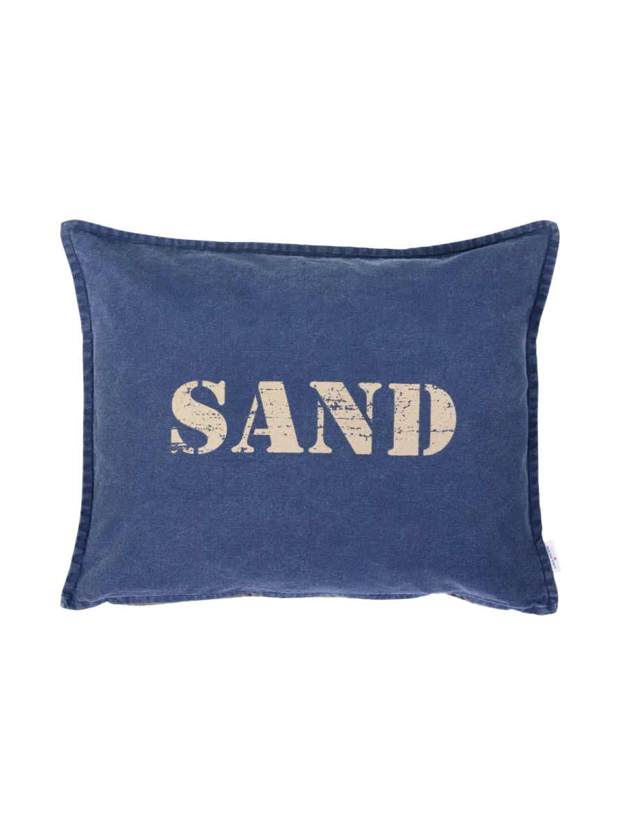Tummansininen tyynyliina, jonka etupuolella vaalea SAND-teksti.