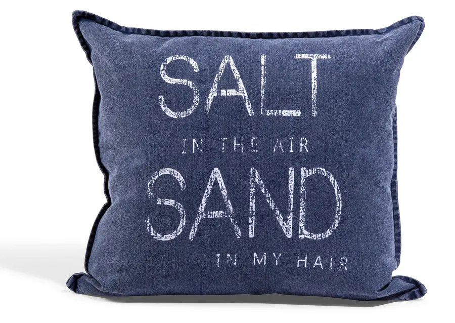 Tummansininen tyynynpäällinen, jossa vaalea teksti Salt in the air, Sand in my hair.