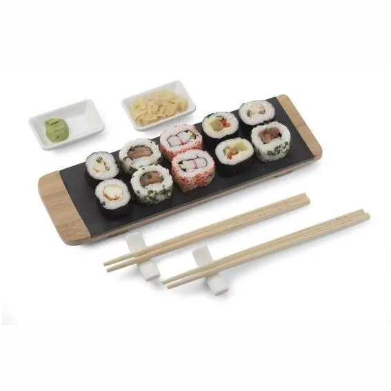 Sushisetti: bambuinen tarjoilulauta kivipinnalla, kaksi valkoista keraamista kulhoa, syömäpuikot ja puikkotelineet.