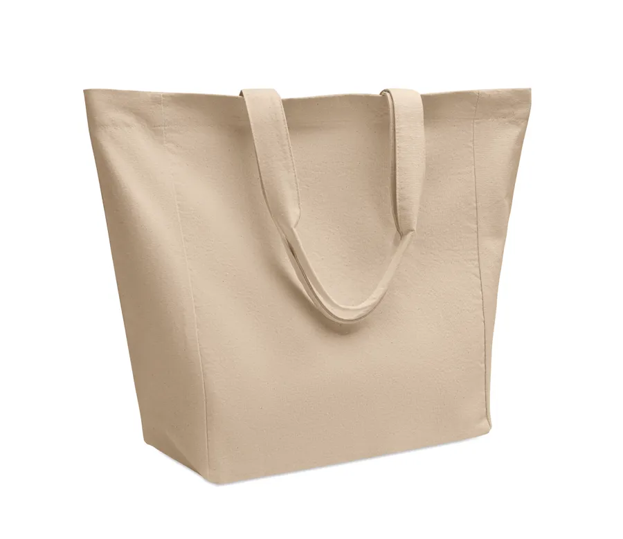 Beige puuvillainen ostoskassi PURI, jossa lyhyet kantokahvat ja levennetty pohja.