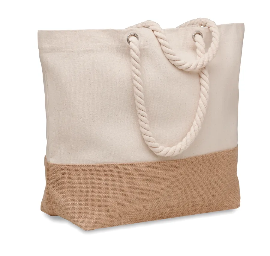 Beige canvas-rantalaukku, jossa juuttinen alaosa ja punotut narukahvat.