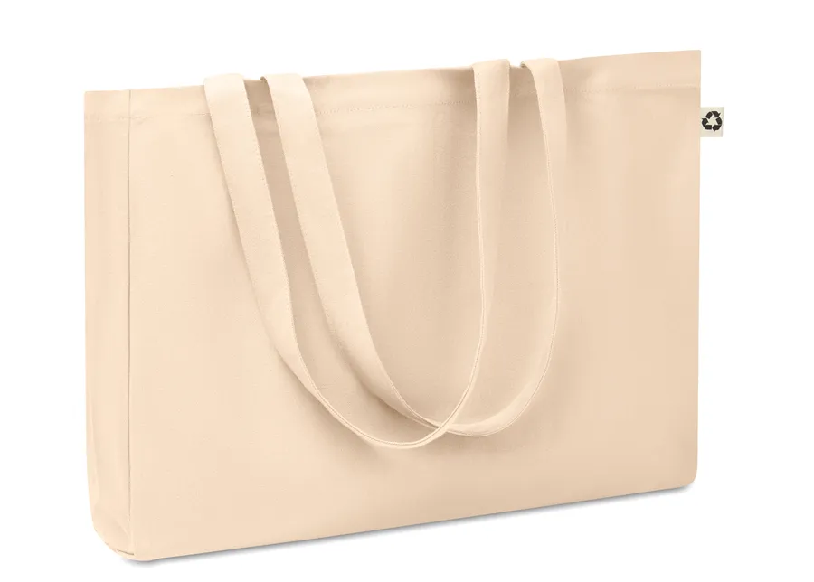 Beige canvas-kassi, jossa pitkät kahvat ja pohjalevike.