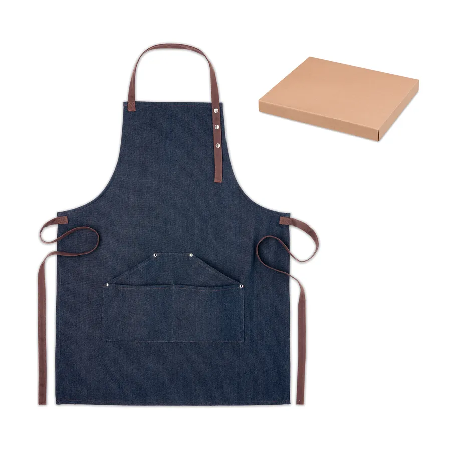 Sininen denim-esiliina, jossa ruskeat hihnat ja etutaskut, sekä ruskea pakkauslaatikko.
