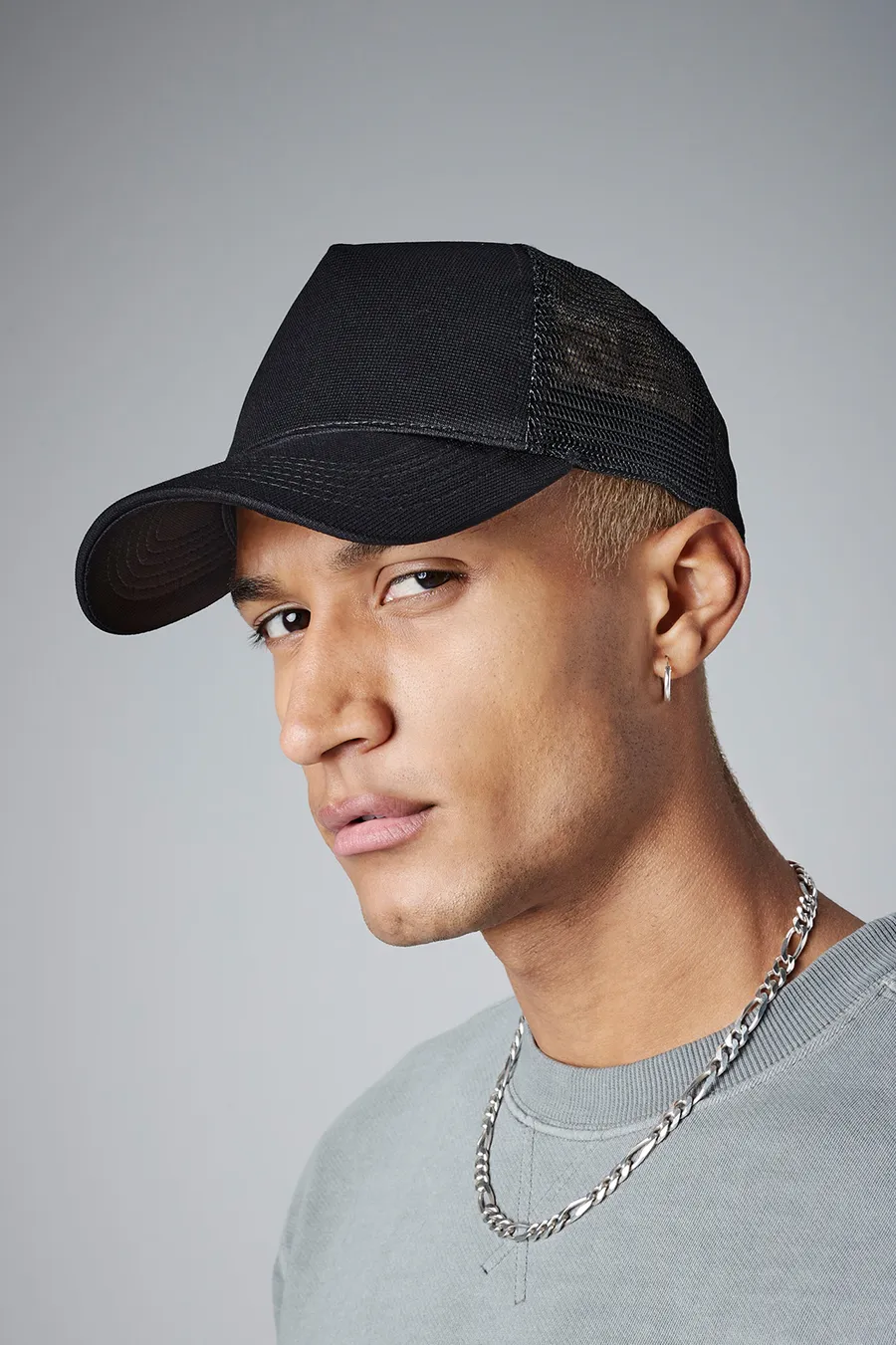 Musta trucker-lippis, jonka etuosassa näkyy vaalea painatus.