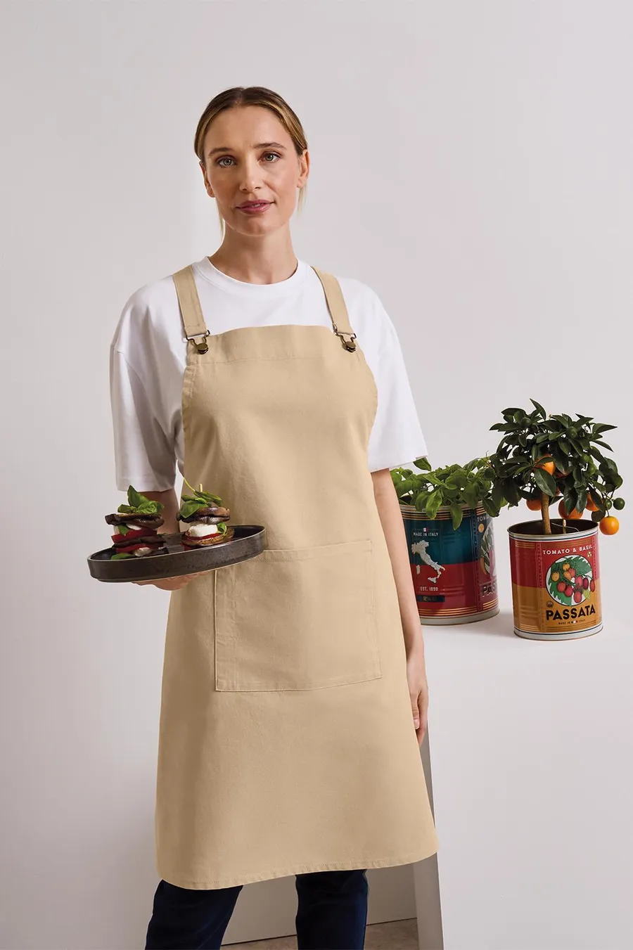 Beige cross back -essu, jonka etupuolella näkyy värikäs painatus.