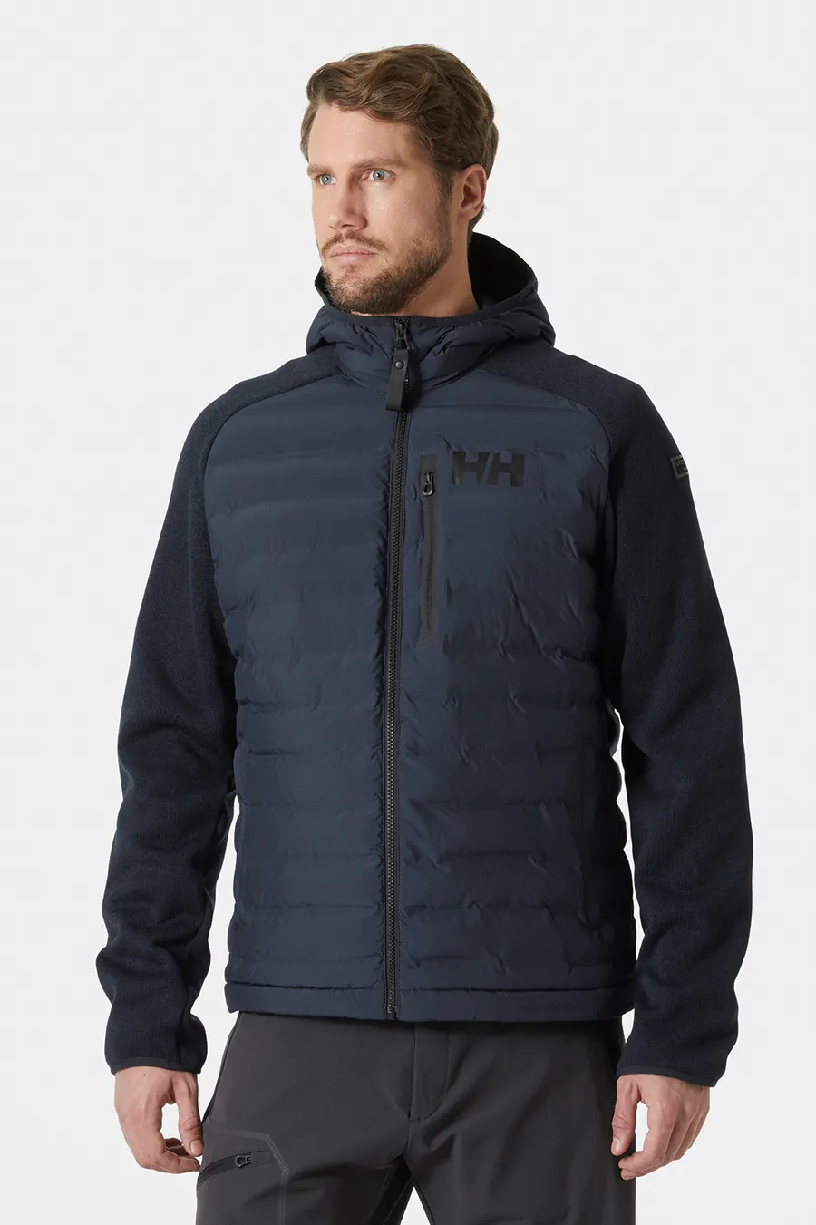 Tummansininen hupullinen Arctic Ocean Hybrid Insulator -takki miehen päällä.