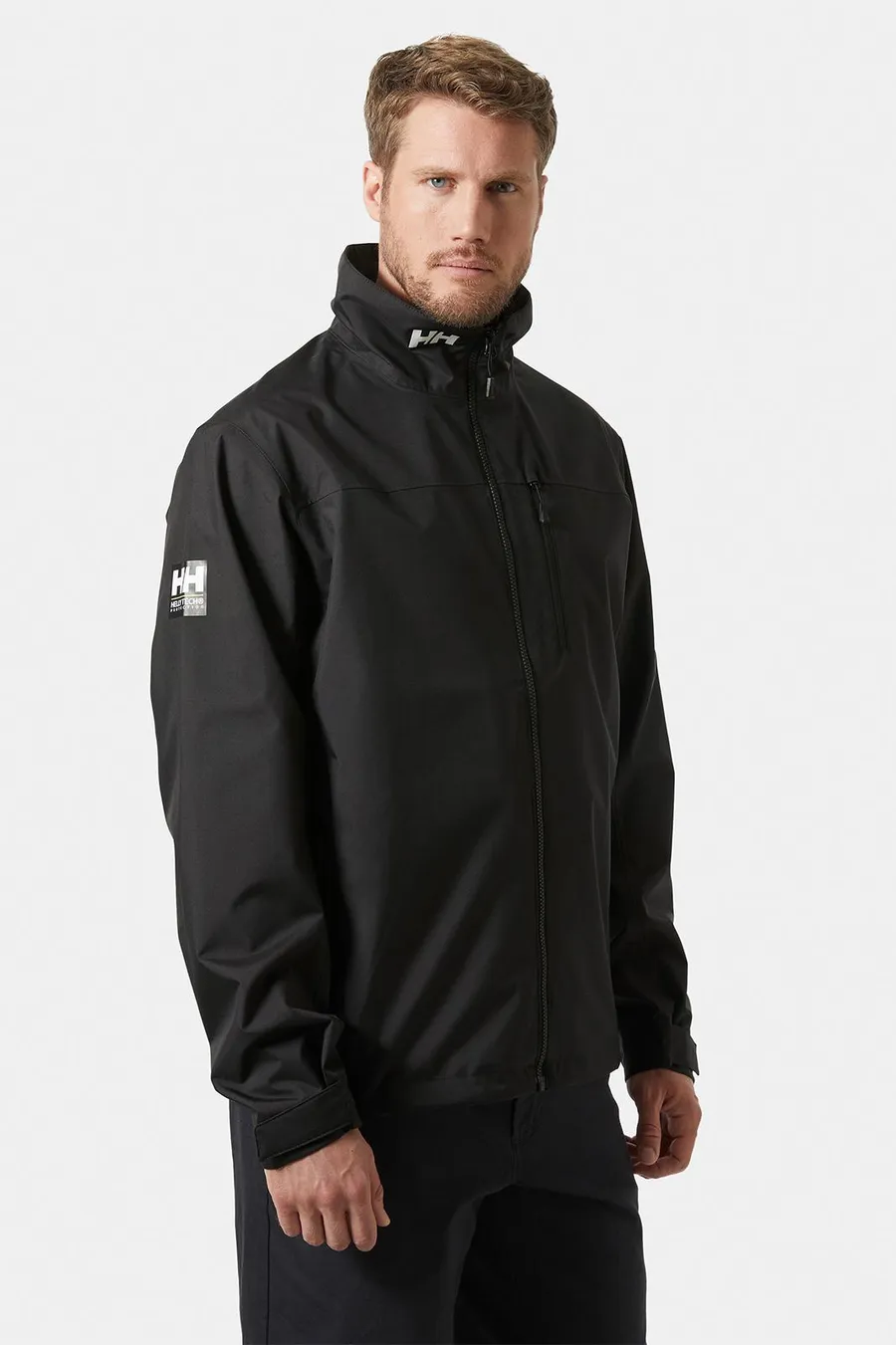 Musta Helly Hansen Crew takki 2.0, jossa on valkoinen logo hihassa.