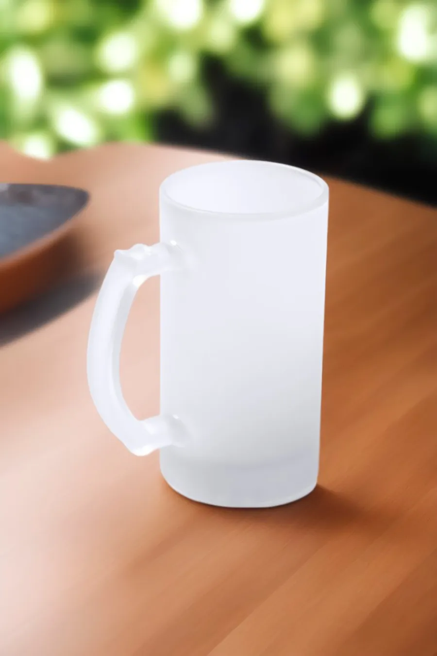 Huurrelasinen 500 ml:n tuoppi korvalla puisella pöydällä.