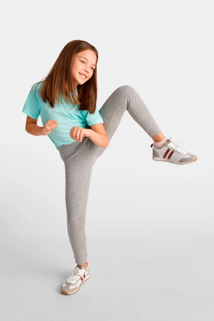 Tyttö yllään meleeratun harmaat Leire-legginsit ja turkoosi t-paita.