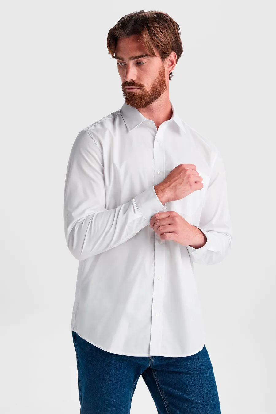 Valkoinen pitkähihainen Aifos-popliinipaita miehen päällä.