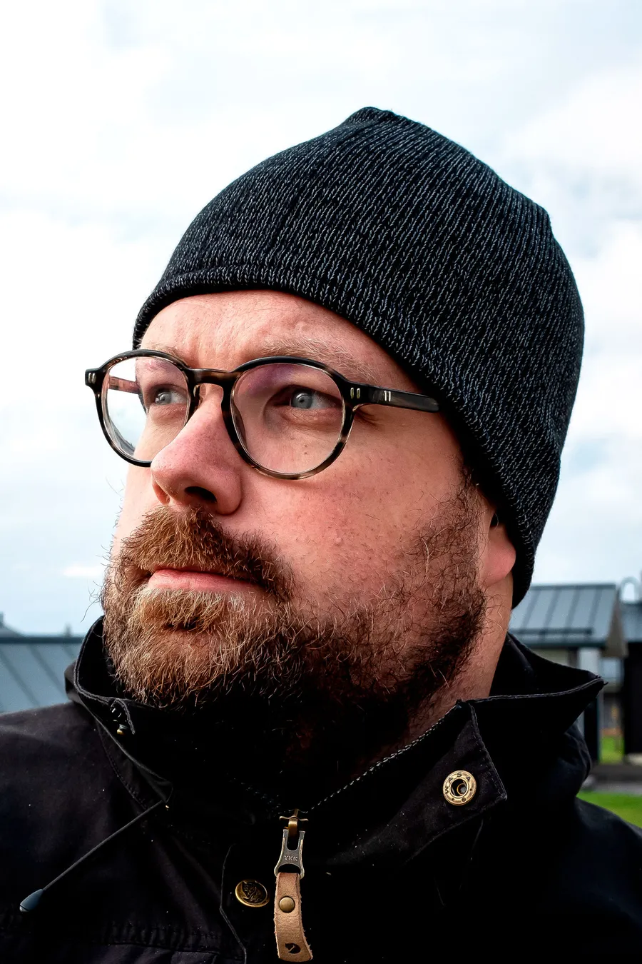 Musta heijastava pipo käännetyllä lierillä miehen päässä.