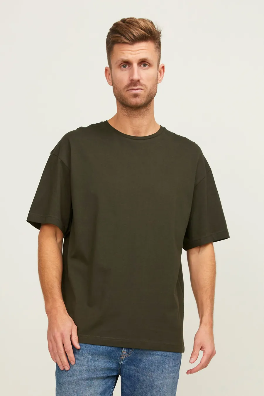 Tummanvihreä oversized-mallinen t-paita miehen päällä.