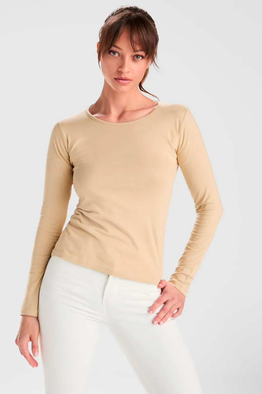 Naisten beige pitkähihainen t-paita yllä, pyöreä pääntie, ei painatusta.