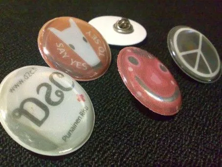 Round reflective soft badges with pin fastening, printed with a dog, text, smiley face and peace sign.