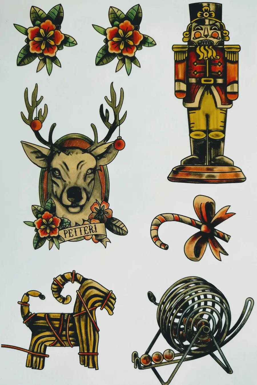 Transfer tattoo sheet with Christmas motifs: flowers, nutcracker, reindeer head, candy cane and straw goat.