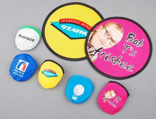 Cloth frisbees in various colours folded into pouches, printed with different logos and images.